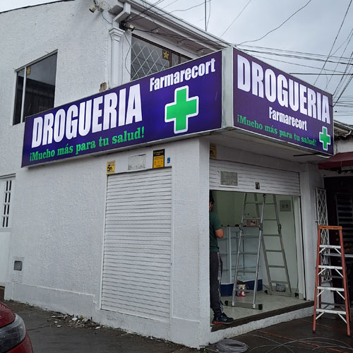 aviso caja de luz en panaflex doble cara en esquina de droguería, iluminación led